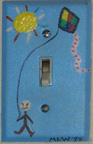 Photo: Painted switchplate of a boy flying a kite, by Marguerite Williams.