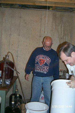 All except the last inch or two of the carboys are siphoned into large buckets. The yeast remnants remain behind in the carboys.