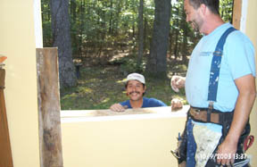 Sal and Bud from Professional Exteriors, Inc., prepare a hole in the wall for a new window.